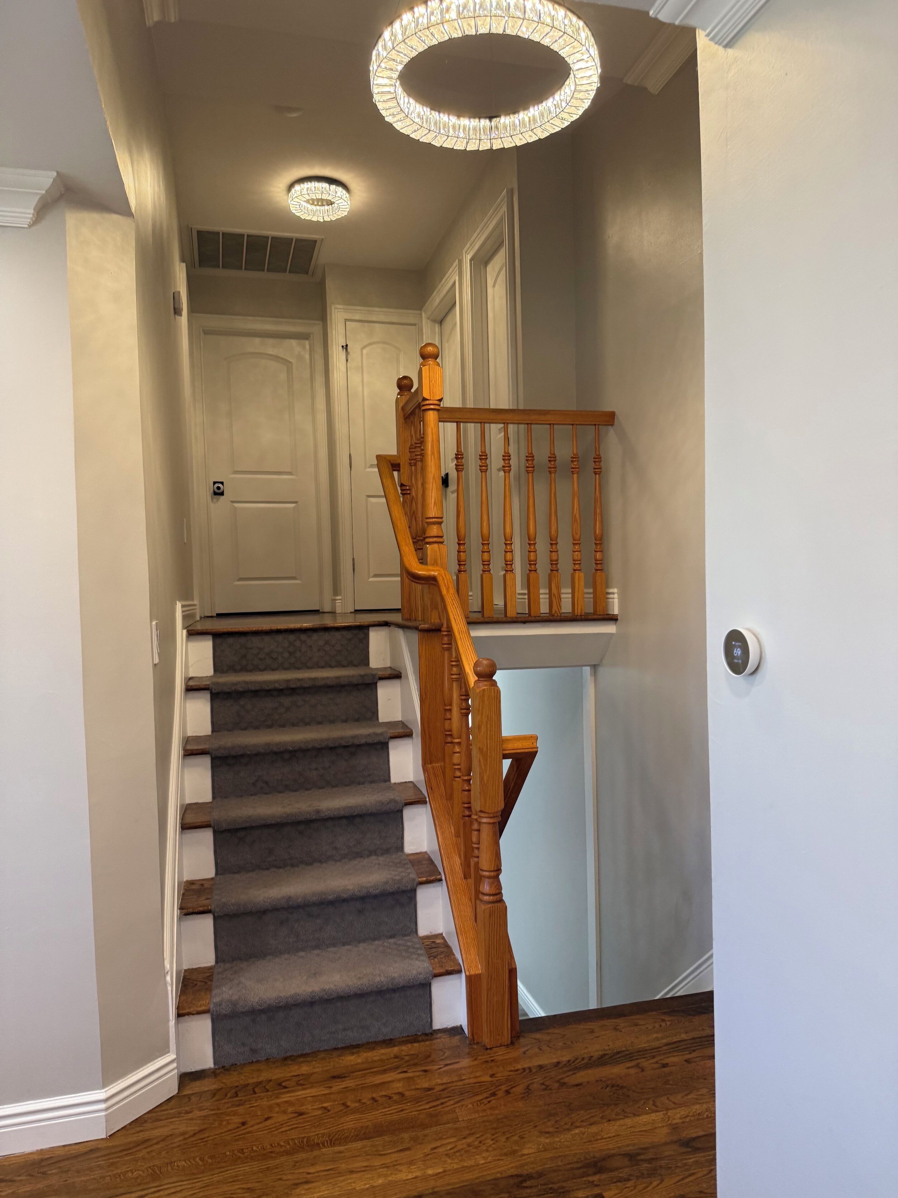 A staircase with wooden balusters and a carpeted landing.