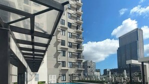 A modern building with a rooftop pool, surrounded by other high-rise buildings. - Studio Unit with Balcony + City & Mountain Views + Fast WiFi | Near IT Park (Cebu City)