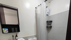 A bathroom with a white sink, toilet, and shower curtain. - Studio Unit with Balcony + City & Mountain Views + Fast WiFi | Near IT Park (Cebu City)