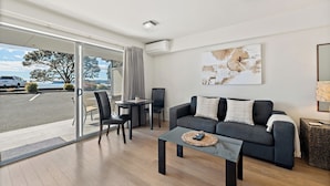 Uma sala de estar moderna com sofá, mesa de centro e canto de jantar com cadeiras e mesa.
