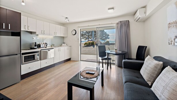 Cozinha moderna com área de refeições, sofá e vista para o exterior.