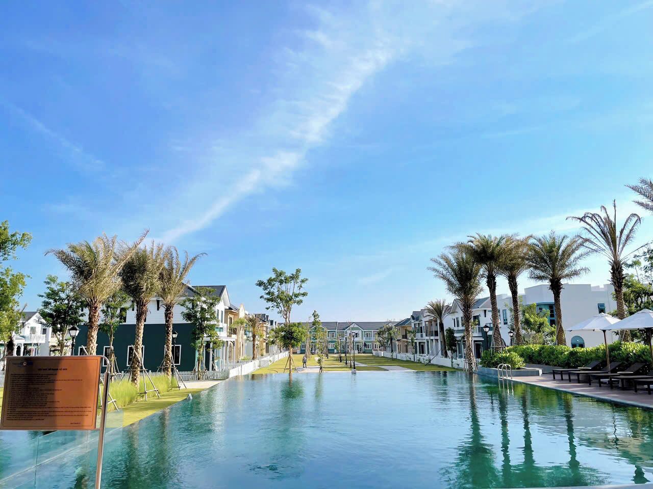 A swimming pool with a clear view of the surrounding buildings and palm trees.