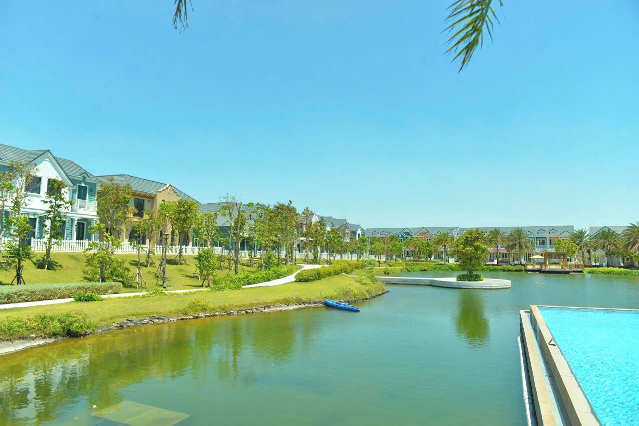 A resort with a swimming pool, a small lake, and a boat.