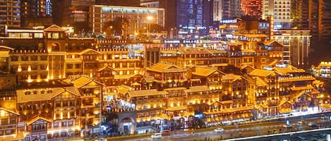 A traditional Chinese architectural area with multiple buildings, a busy street, and a bridge.