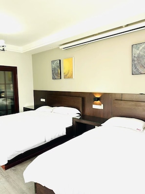 Quarto quádruplo conforto, 2 camas Queen, vista para a cidade | Área de estar
