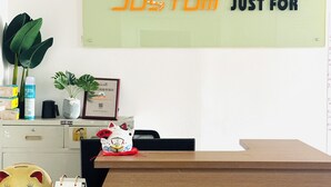 En receptionsdisk med et skilt der siger "Just for" og et logo over.