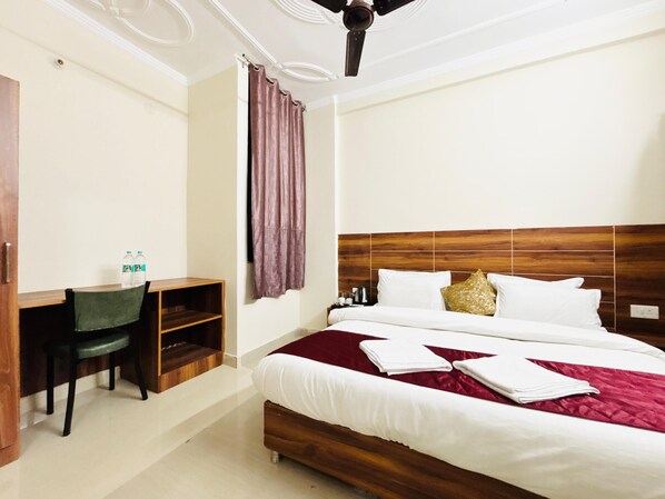 Una habitación de hotel con cama, escritorio y una silla.