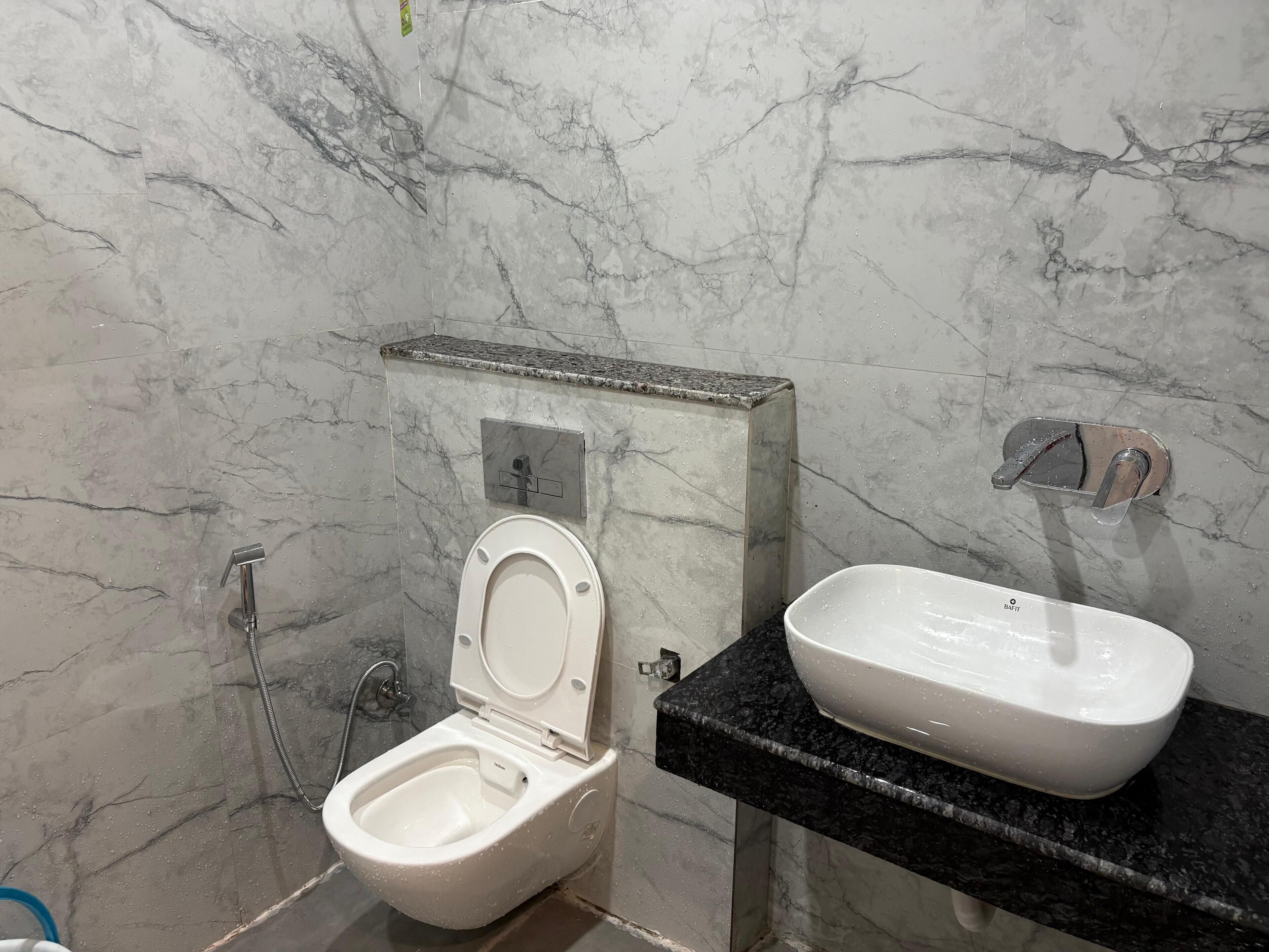 A bathroom with a toilet, bidet, and sink.