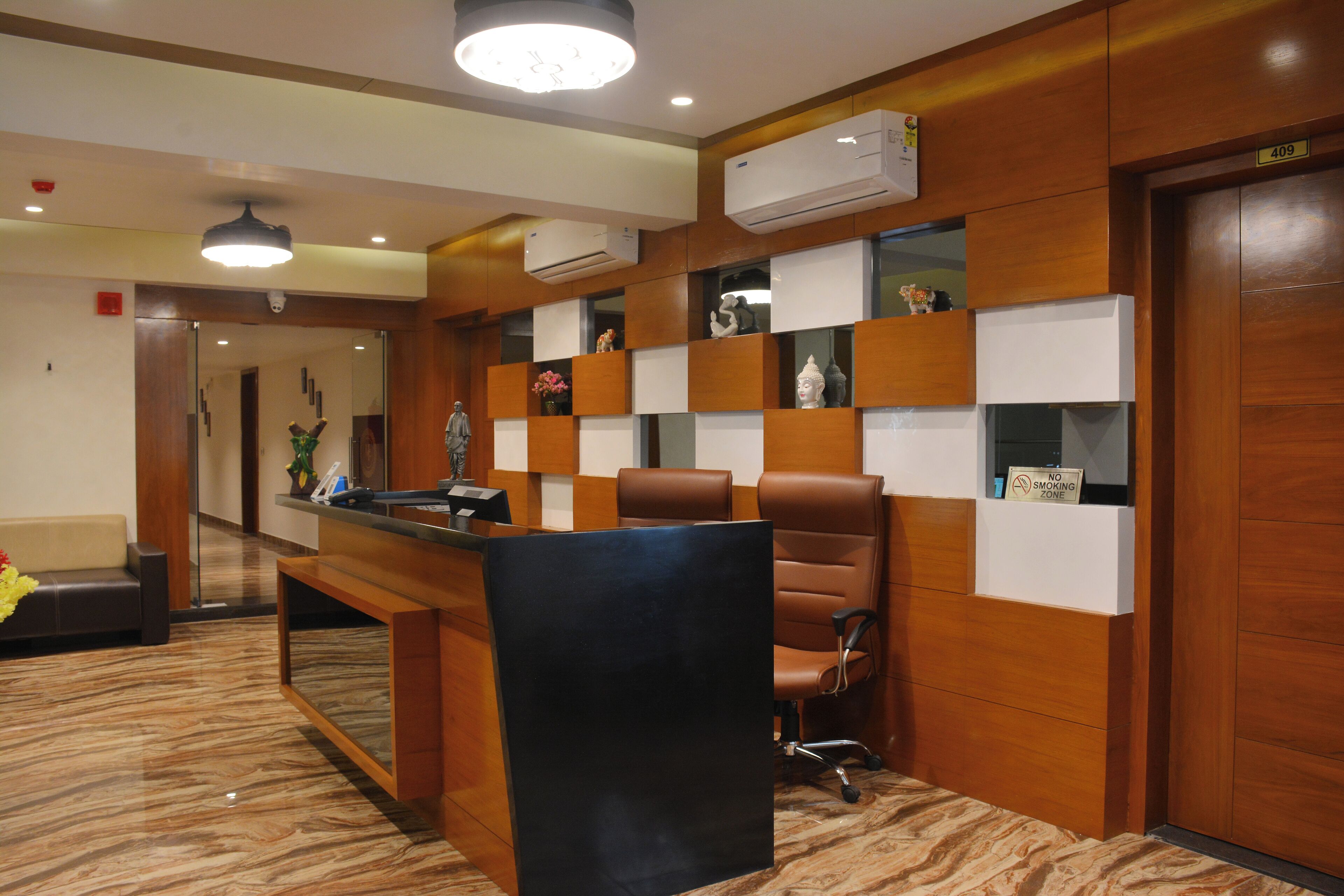A reception area with a reception desk, seating, and a 'No Smoking' sign.