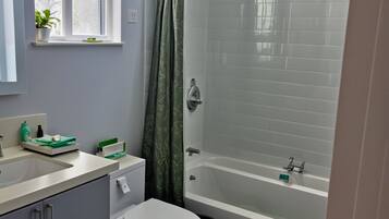 A modern bathroom with a toilet, sink, and bathtub.