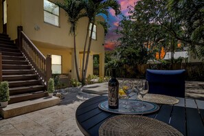 A patio with a round table, chairs, and a bottle of wine. - Upscale Home - CityPlace & Convention Center (West Palm Beach)