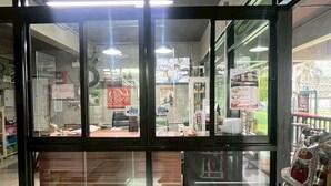 En butiksinredning med en disk, vitrinskåp och en kassazons.