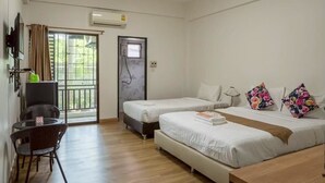 Ett hotellrum med två sängar, ett litet bord, en stol, en TV och en luftkonditioneringsanläggning.