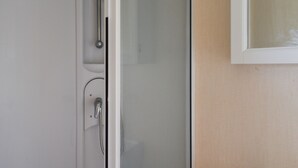 A bathroom with a shower, a sink, and a mirror. - Praise Machine Caravan Experience (St Osyth)