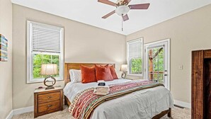 A bedroom with a bed, two bedside tables, a ceiling fan, and two windows with blinds. - Secluded Mountain Top with Game Room and Fire Pit Near Boone (Boone)