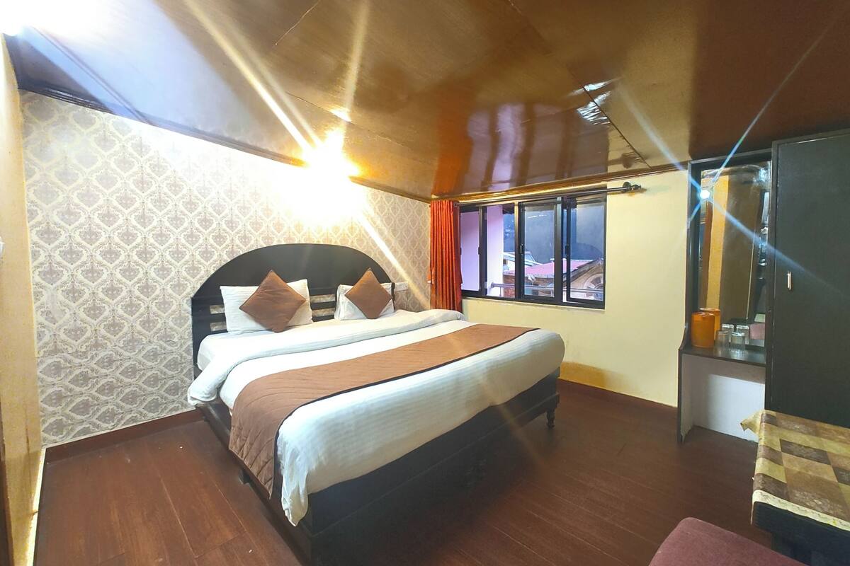 A bedroom with a bed, a window, and a mirror.