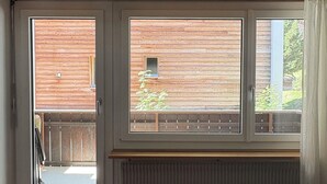 A room with a large window, a radiator below, and a patterned rug on the floor. - Haus Salü 5 by Interhome (Saas-Fee)