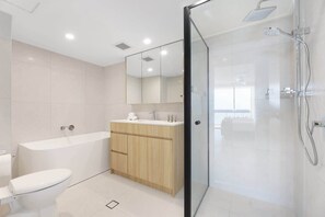 Ein modernes Badezimmer mit Badewanne, Toilette und separater Duschkabine.