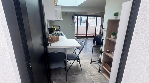 A modern kitchen with a dining area, a black door, a skylight, and a welcome mat. - Pet friendly loft with private terrace (Ciudad de México)
