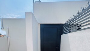 A rooftop terrace with a black door, a metal railing, and a blue mat. - Pet friendly loft with private terrace (Ciudad de México)