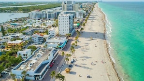 A coastal cityscape with a beach, buildings, and a marina. - New Luxury Beachfront Condo with Rooftop Pool (Hollywood)