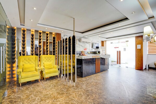 Un hall con mostrador de recepción, sillones amarillos y un diseño de interiores moderno.