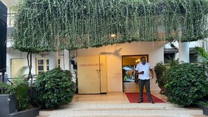 Ein Mann steht vor dem Eingang eines Gebäudes mit der Aufschrift 'SENHOR ANGELO RESORT'.