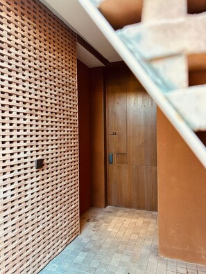 Un pasillo con una puerta de madera y un revestimiento de ladrillo.