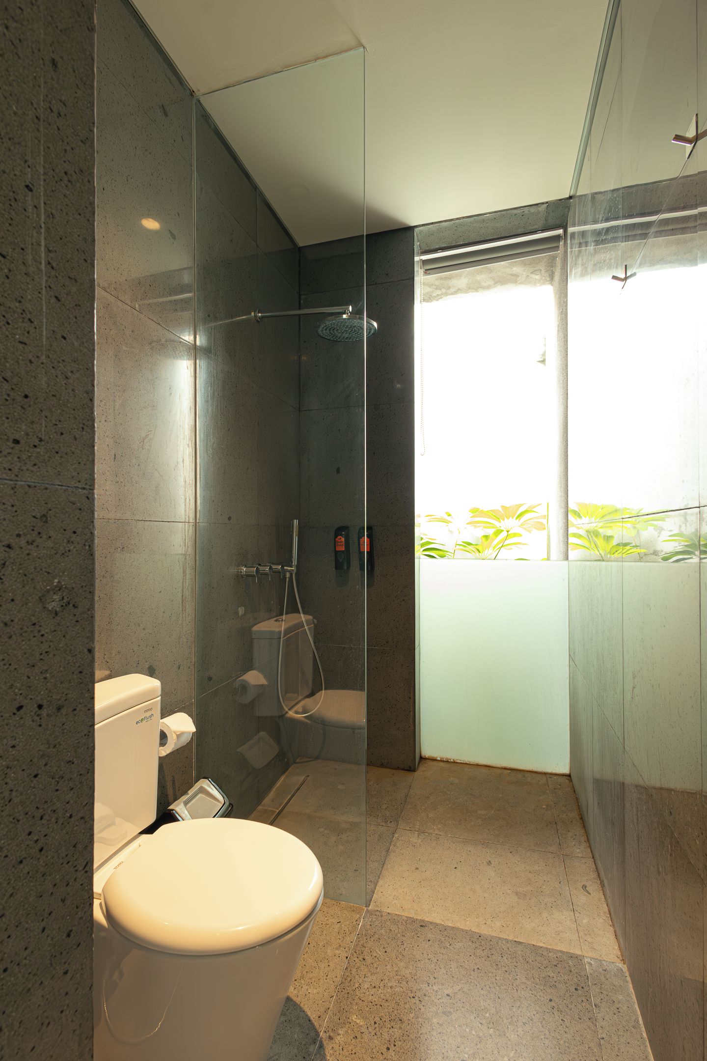 Un baño moderno con ducha envuelta en vidrio, inodoro y bidé.