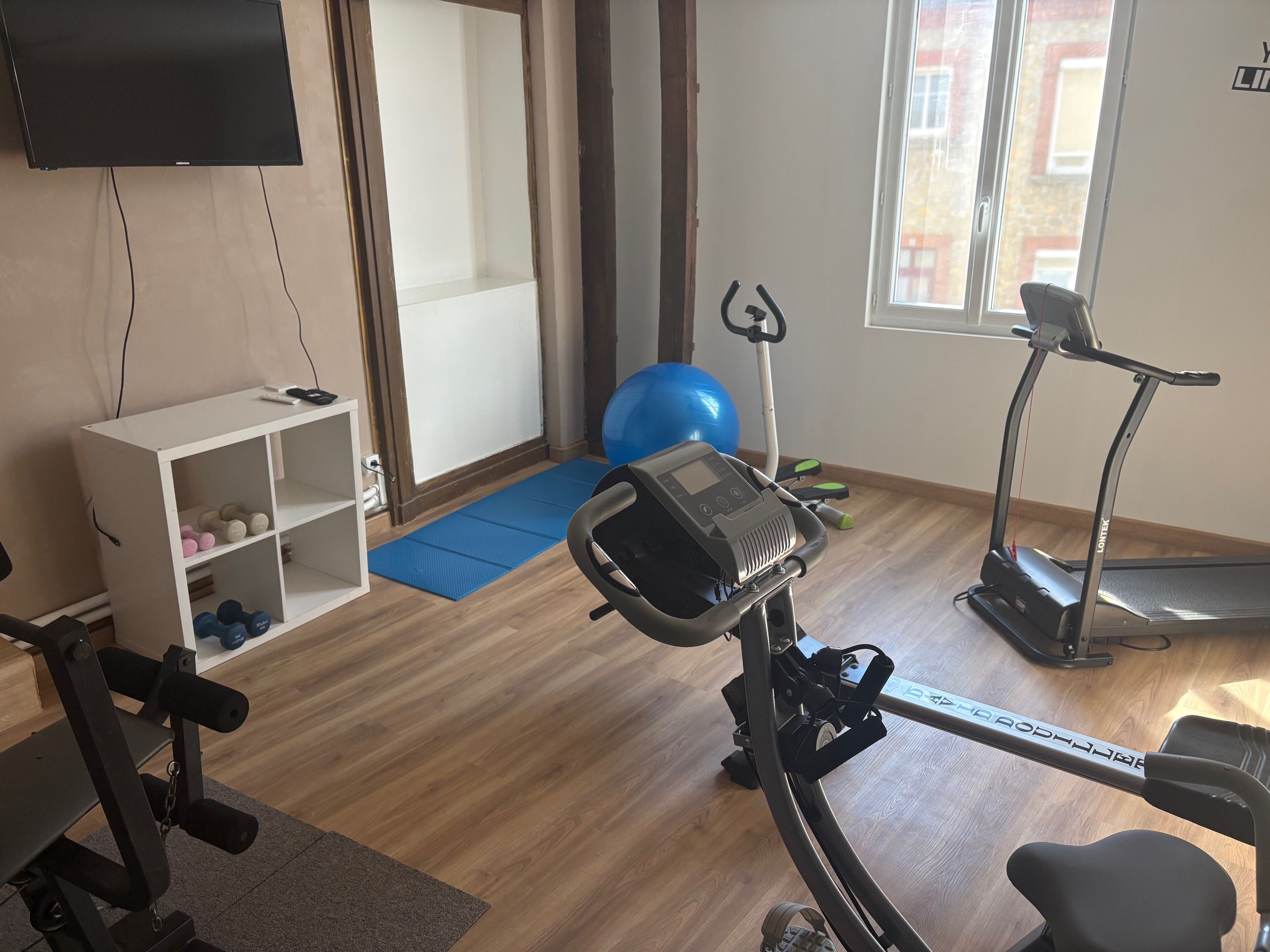 A home gym with exercise equipment, a treadmill, and a stationary bike.