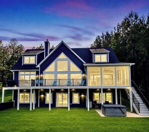 A two-story house with a balcony, large windows, and a staircase leading to an upper level.