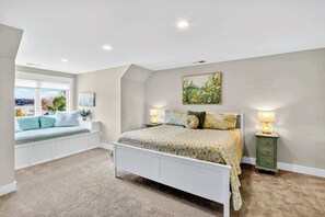 A bedroom with a bed, a nightstand, a window seat, and a painting on the wall. - Lakefront Lake Anna 6-Suites, Hot Tub (Mineral)