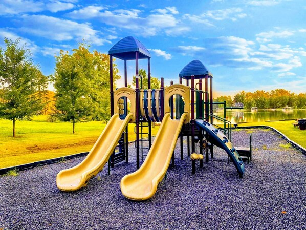Une aire de jeux avec deux toboggans, une structure d’escalade et un kiosque.