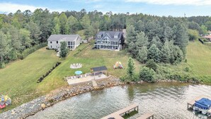 A large house with a deck and a pond.