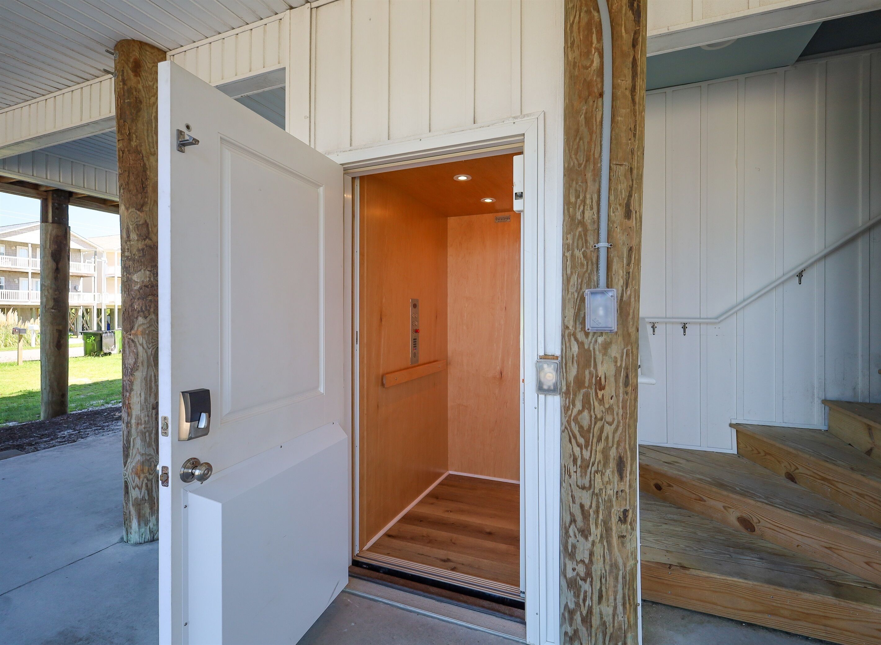An open door to a room with a wooden floor and a light fixture.