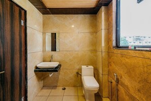 A bathroom with a toilet, sink, and shower.