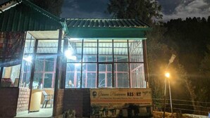 A small, single-story building with a green roof and large windows, labeled as 'Green Heaven Resort'.