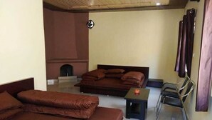 A room with two beds, a small table, and a chair.