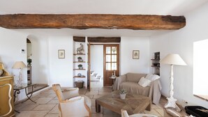 Un salon chaleureux avec un plafond en bois, un canapé, une table basse et une lampe.