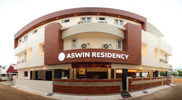 A modern building with a curved facade, labeled "ASWIN RESIDENCY".