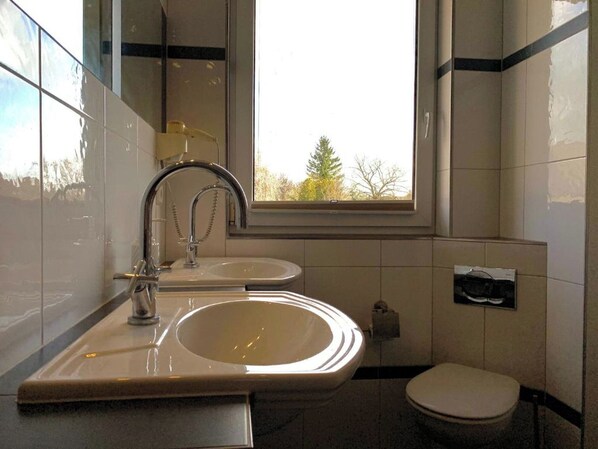 A bathroom with a sink, mirror, and toilet. - Ratskeller Hotel & Restaurant Lindow (Lindow)