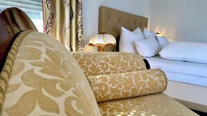 A hotel room with a large bed, a sofa, and a lamp. - Ratskeller Hotel & Restaurant Lindow  (Lindow)