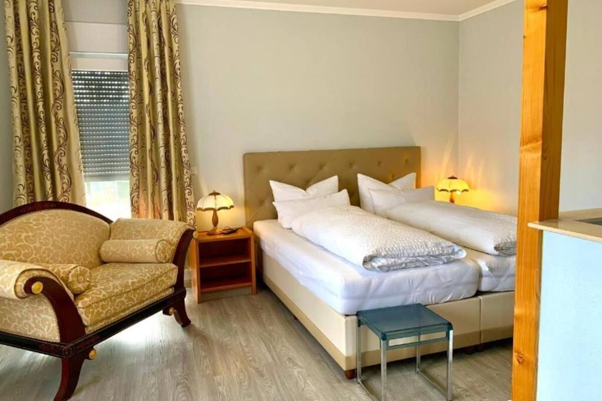 A hotel room with a bed, two bedside tables with lamps, a chair, and a small table.