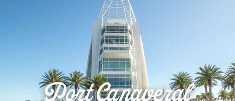 Un edificio moderno con un original diseño triangular, rodeado de palmeras y una masa de agua.