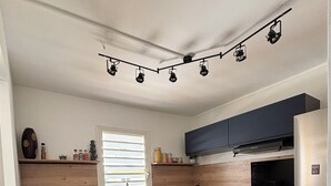 Una cucina moderna con pensili blu scuro, un piano in legno, un frigorifero in acciaio inossidabile e un forno a incasso.