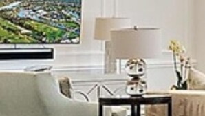 Ein Wohnzimmer mit einer Couch, einem Couchtisch und einem Fernseher an der Wand.