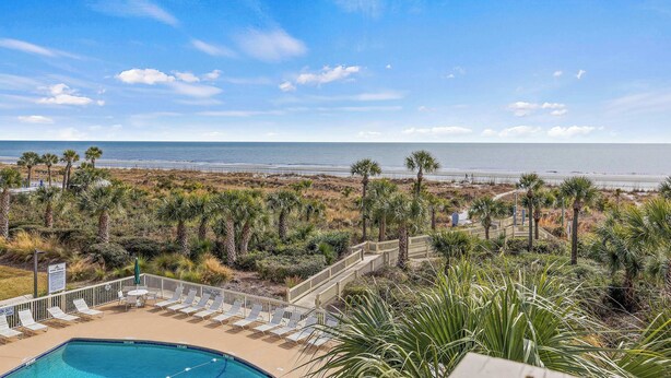 A pool area with lounge chairs and a view of the beach. - Oceanfront Retreat 318 Breakers (Hilton Head Island)