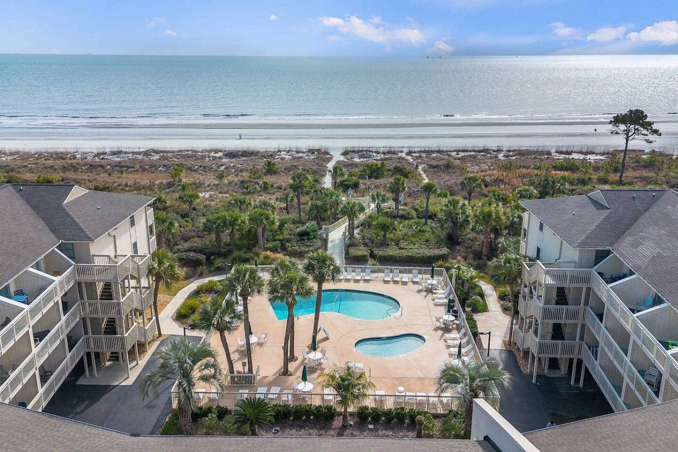 Un resort con zona de piscina, varios balcones y vistas al océano.