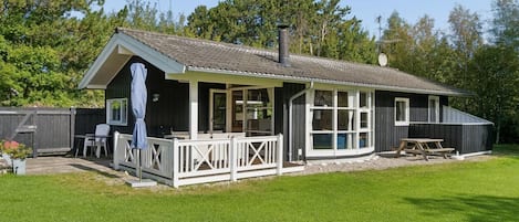 A two-story house with a covered porch and a fenced yard.