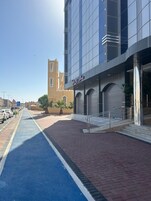 A modern building with a blue bike lane and a pedestrian area.